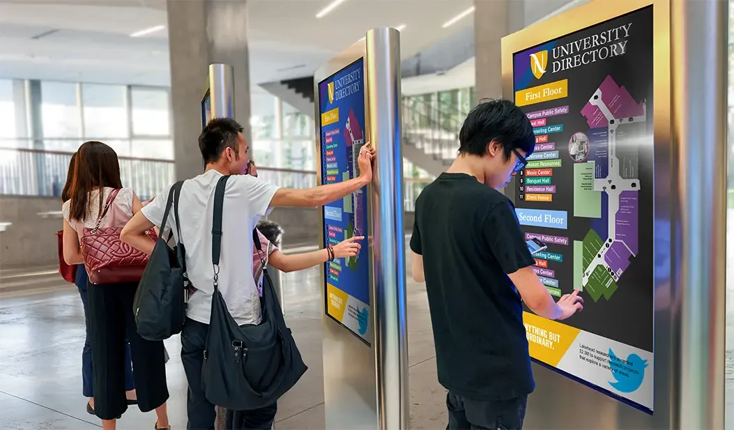 Des étudiants utilisant un répertoire interactif du campus
